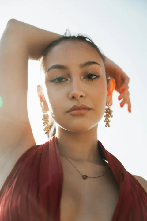Young woman in red dress with jewelry looking at camera