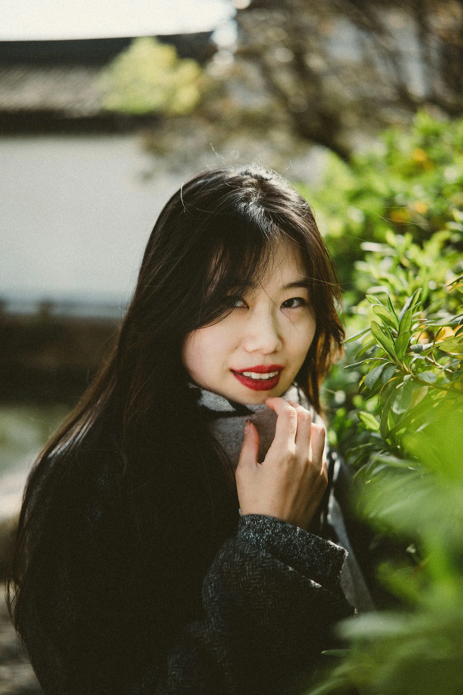 長髮女子站在灌木叢旁