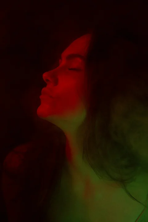 a woman with her eyes closed in the dark