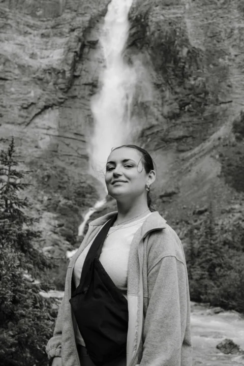 A woman standing in front of a waterfall