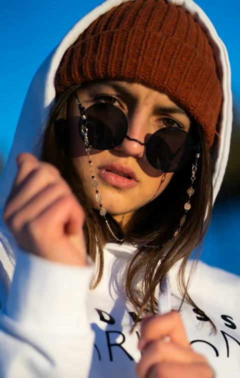 a woman wearing sunglasses and a hoodie