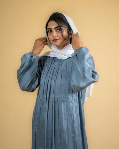 a woman in a blue dress is holding her head