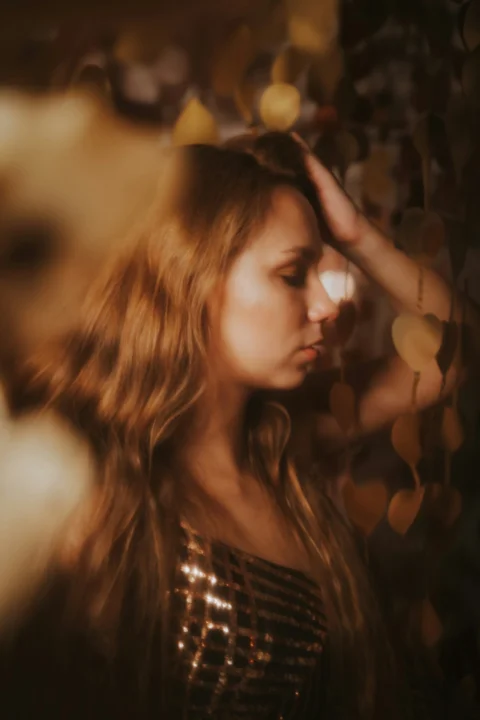 A woman with long hair standing in front of a wall