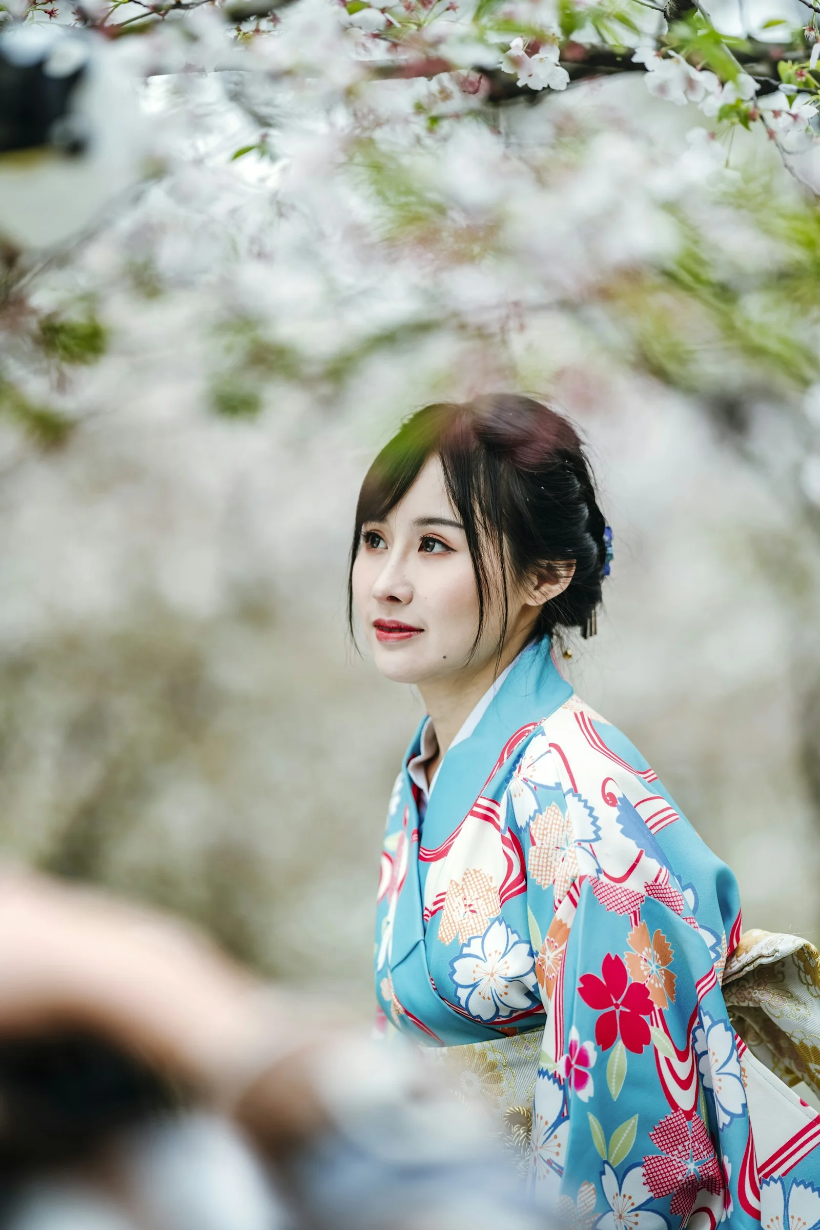 白地に赤と青の花柄の着物を着た女性