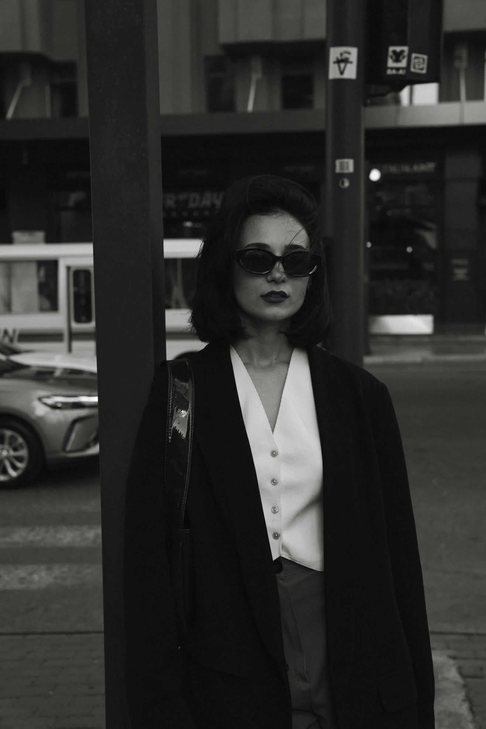一个女人站在人行道上的一根杆子旁