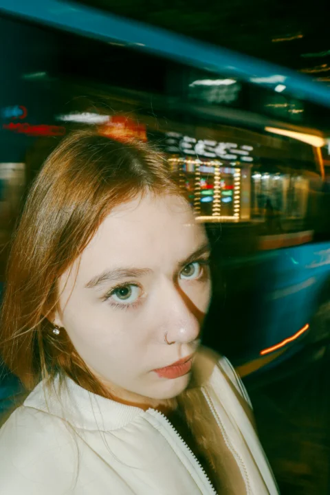 一位红发蓝眼的女子站在公共汽车前