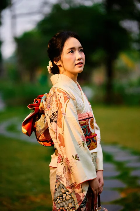 Woman in traditional japanese kimono looking up in a garden