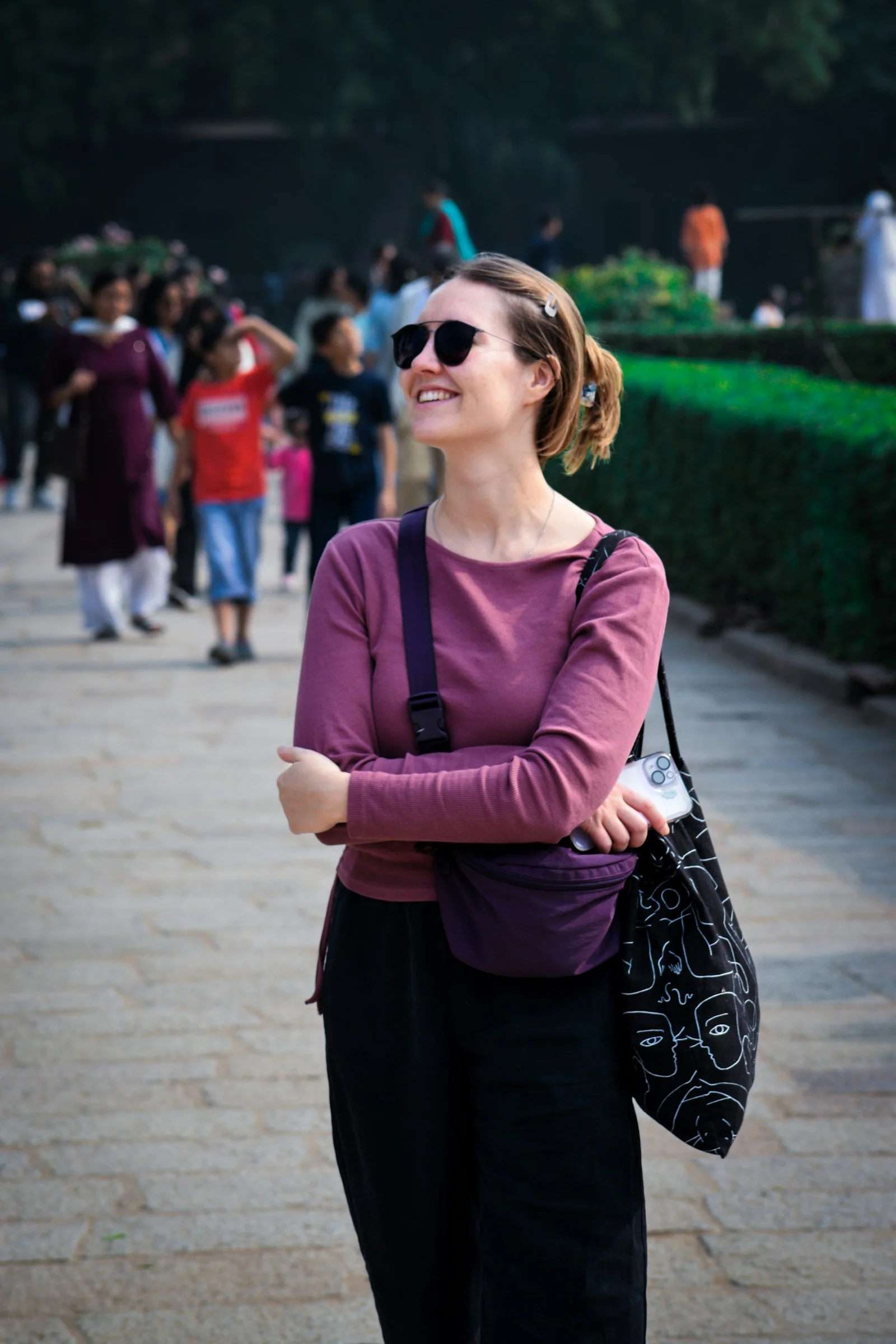 A woman standing on a sidewalk with her arms crossed
