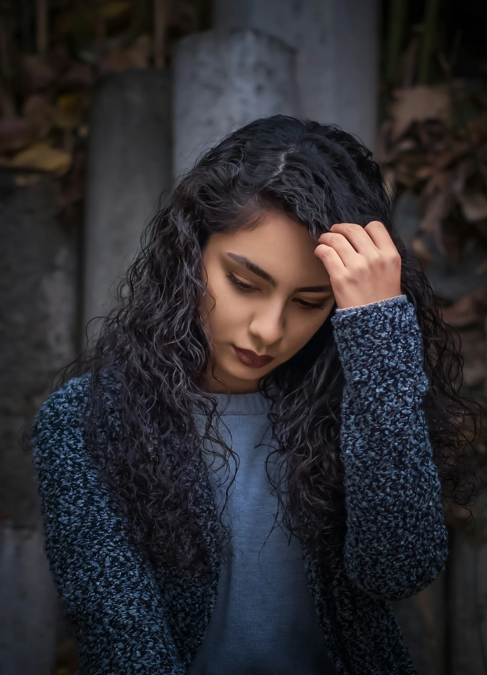 一名长卷发女子用手扶着头
