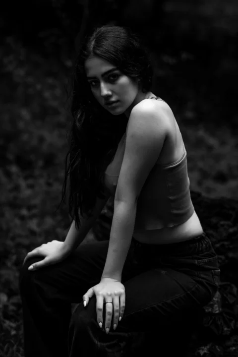 A woman poses in a dark, black and white photo