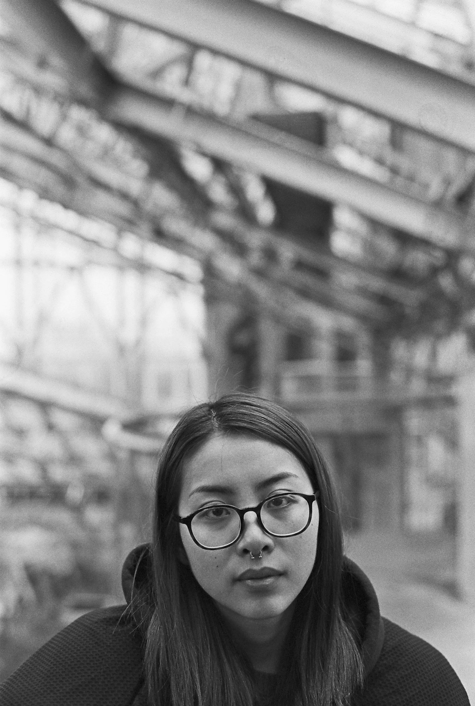 greyscale photo of woman wearing hoodie and eyeglasses