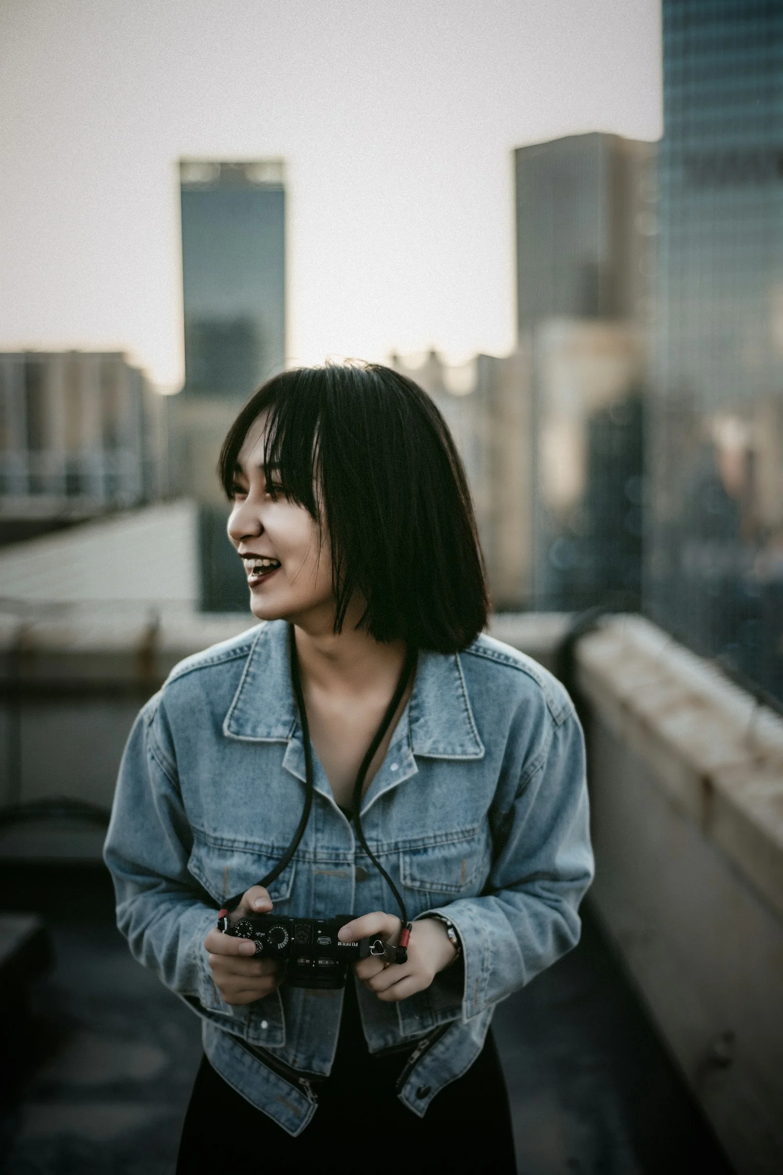 a woman standing on a roof holding a camera
