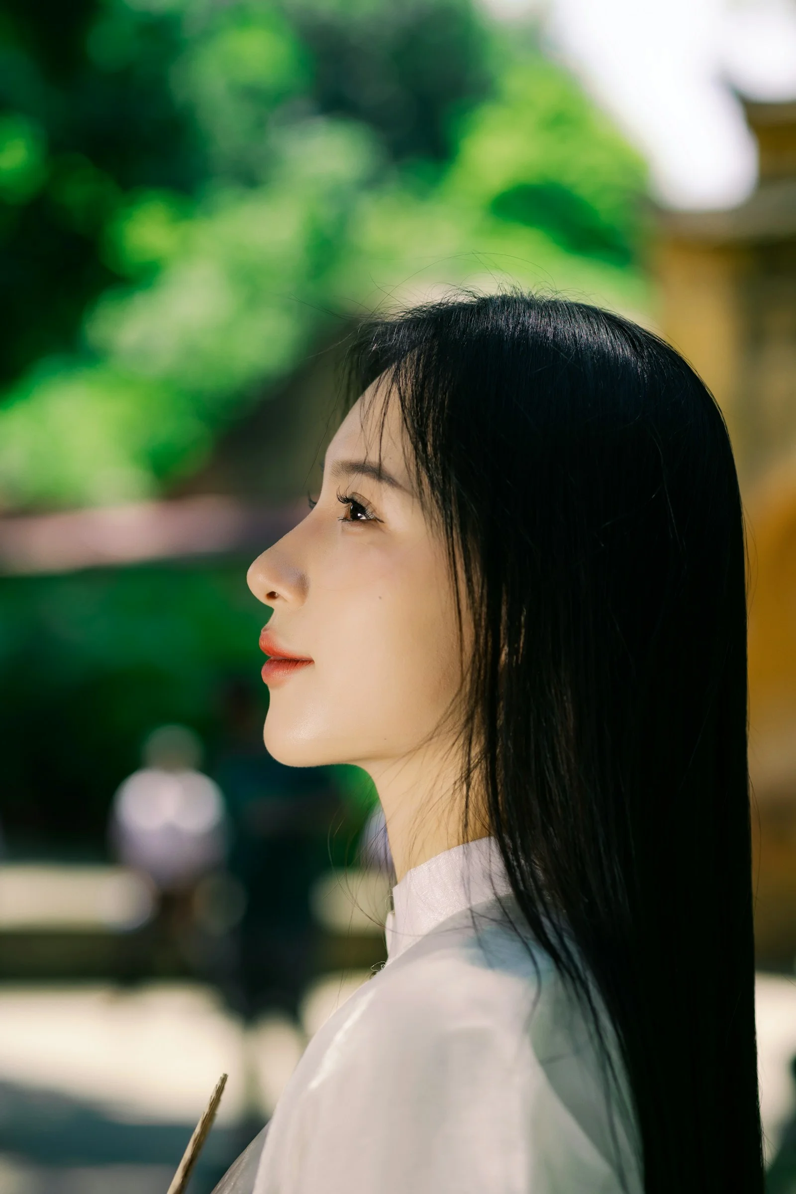 A woman with long black hair and a white shirt