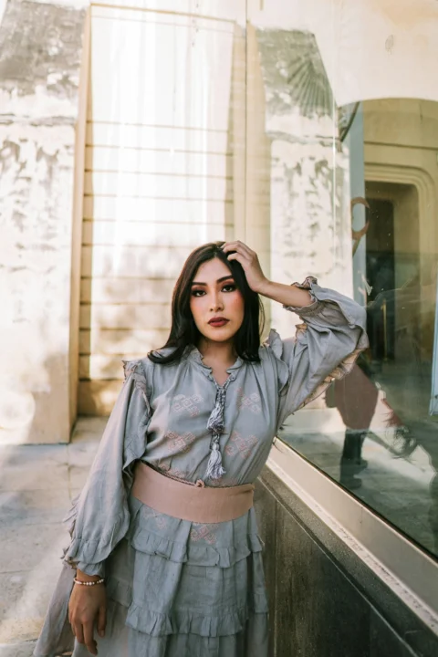 Woman poses gracefully in a vintage-style outfit