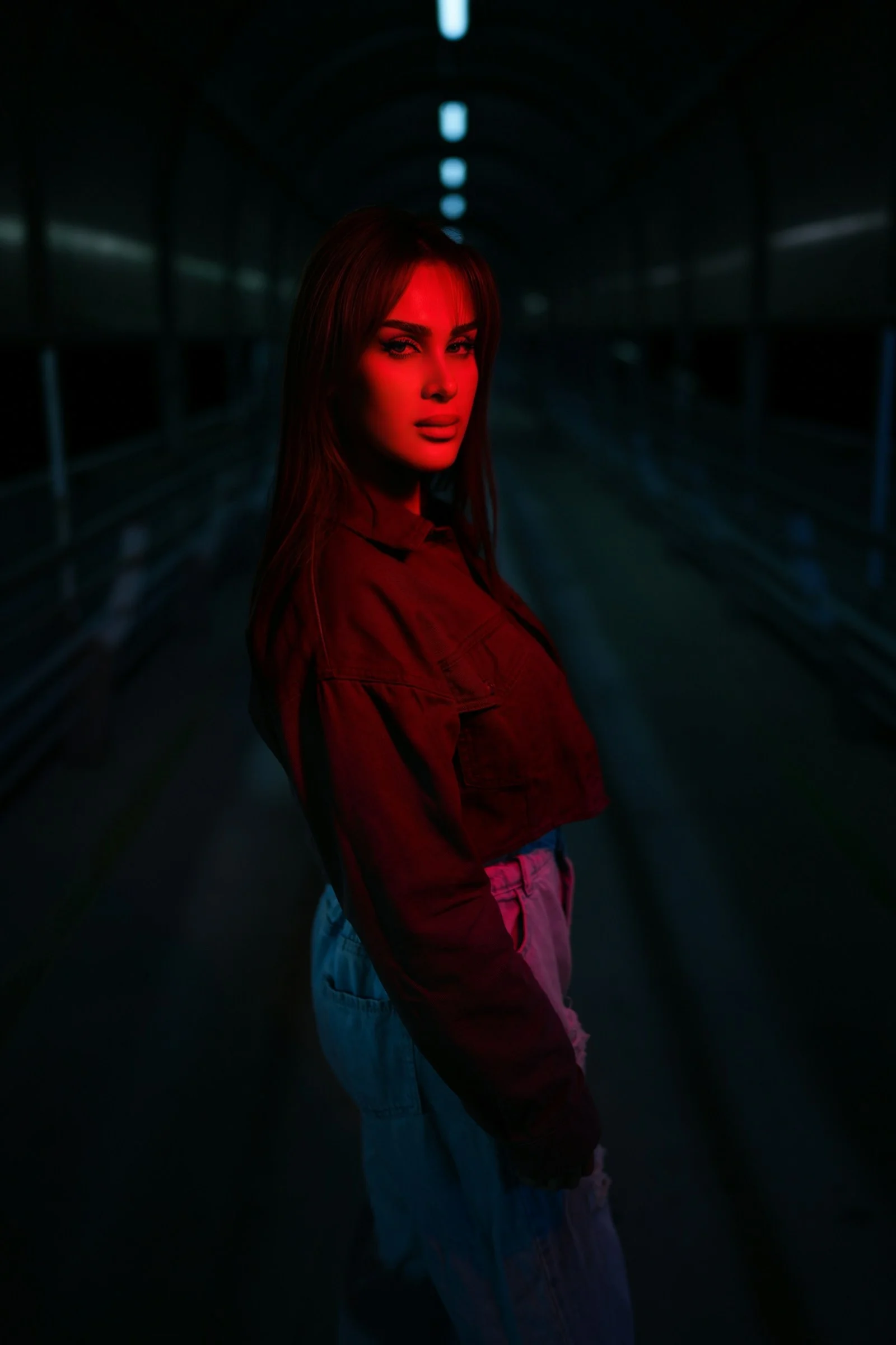 女人在黑暗的走廊中被红光照亮