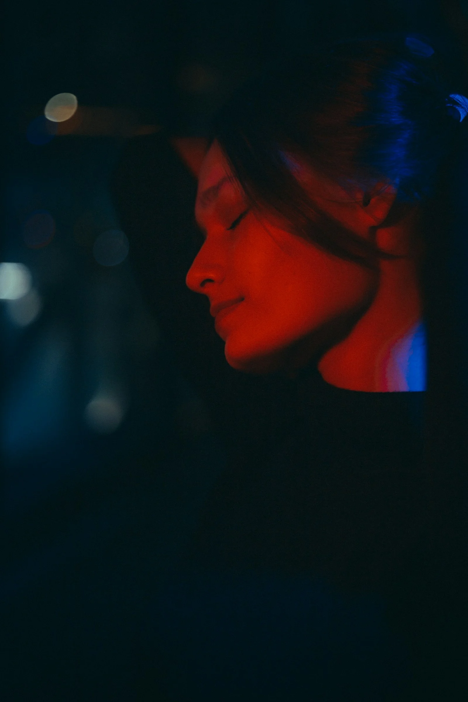 一位女子在黑暗中閉著眼睛