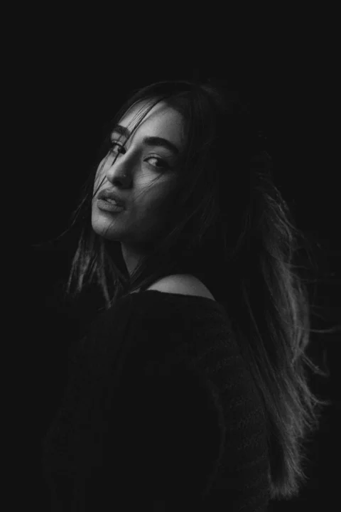 A woman with windswept hair looks over her shoulder