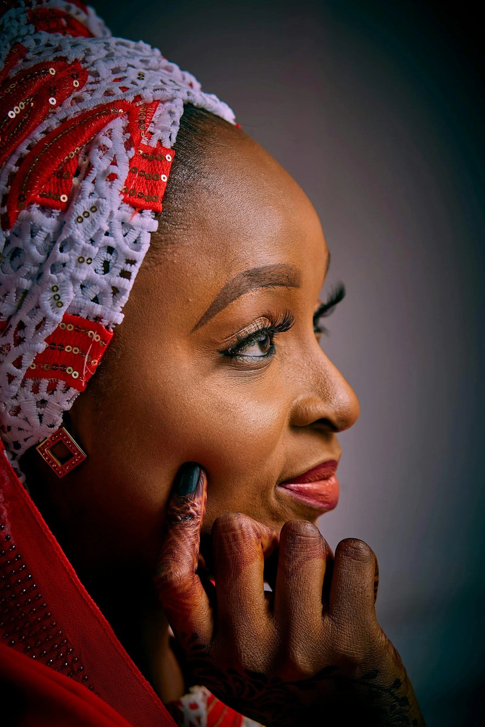 A woman with a headscarf looks thoughtfully