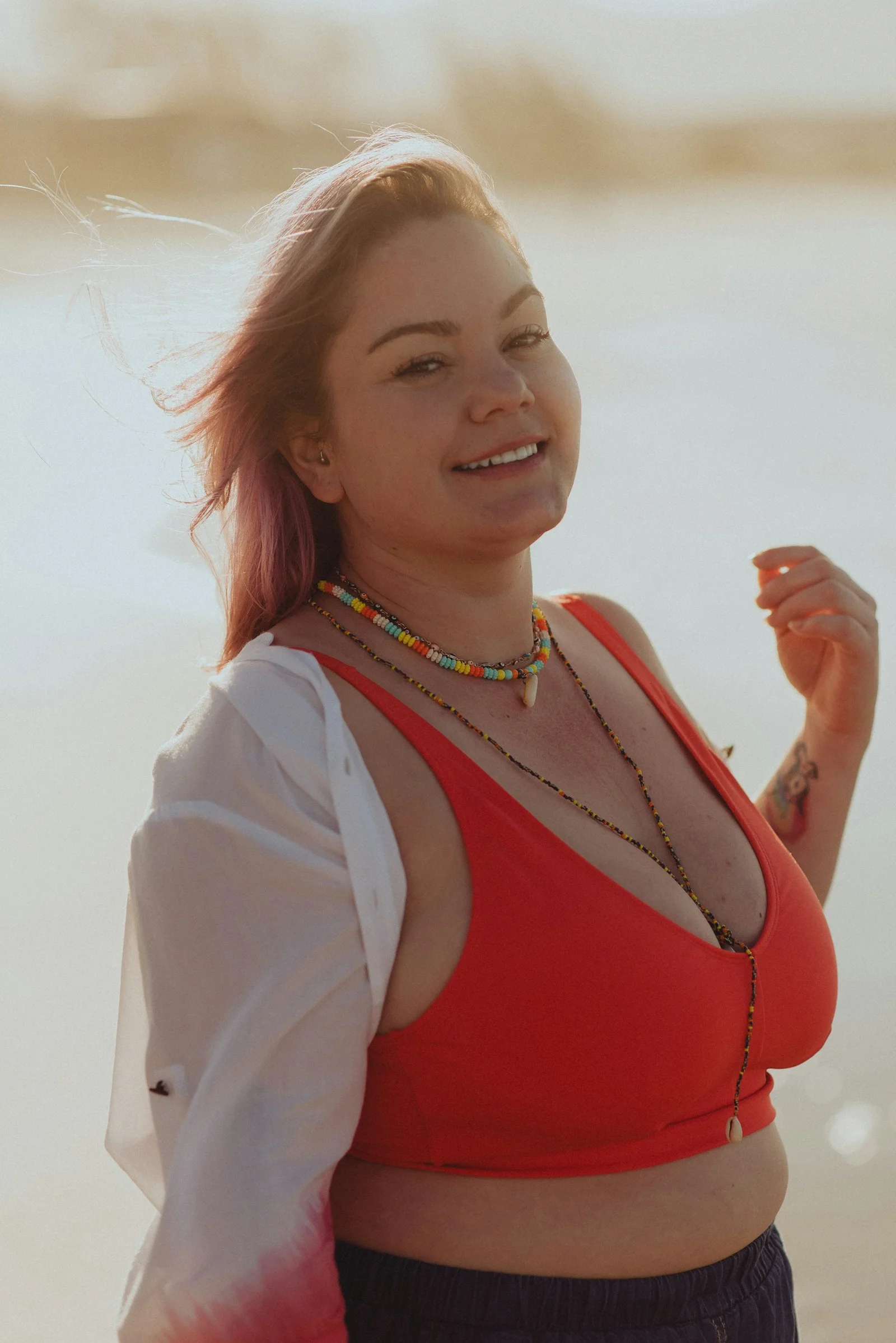 a woman with a red top and a necklace
