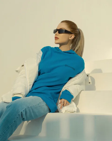 a woman sitting on a set of stairs wearing sunglasses