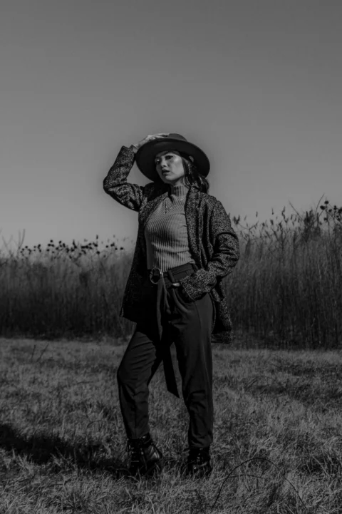 戴帽子的女人站在草地上
