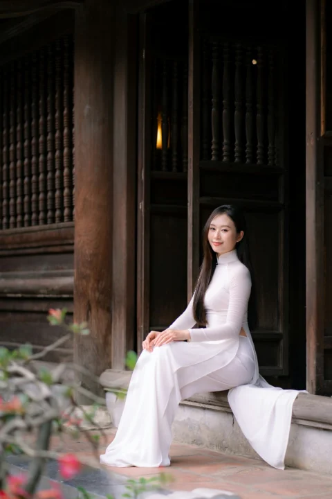 A woman in white sits in an old doorway