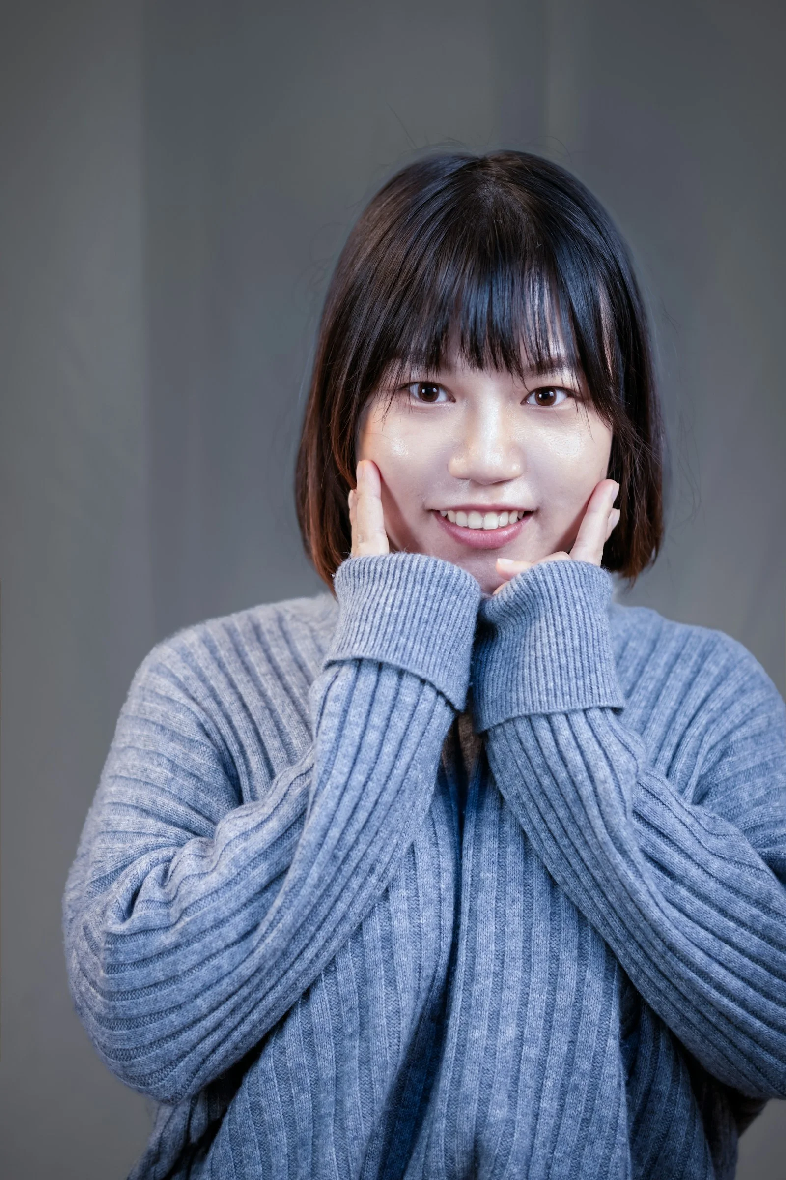 a woman posing for a picture with her hands on her face