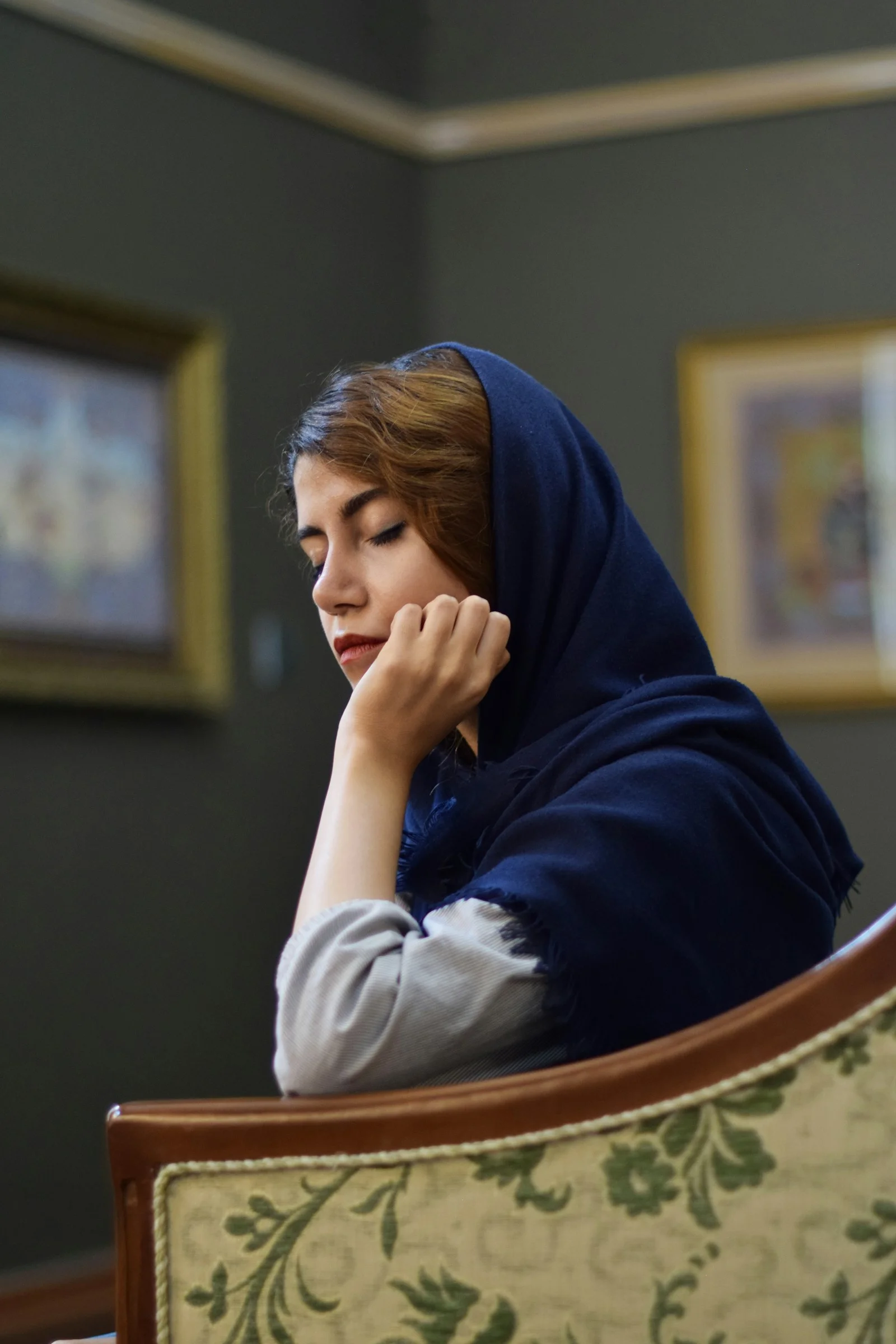 Woman contemplates, resting her chin in thought