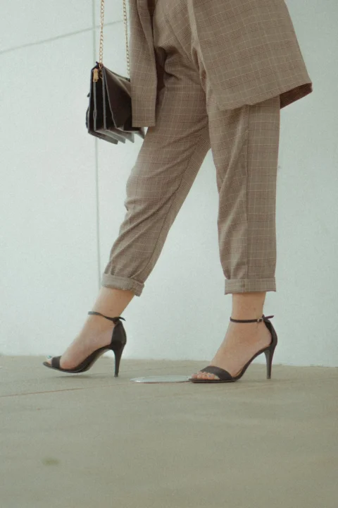 person wearing brown pants and black heels