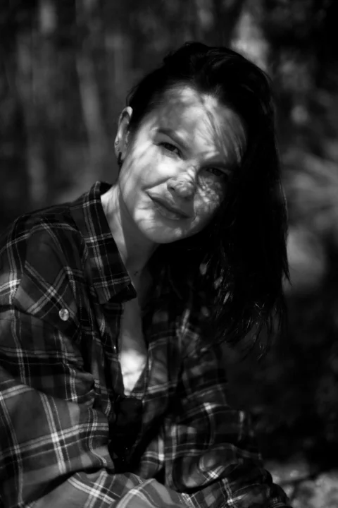 Woman's face is shaded with leaf patterns