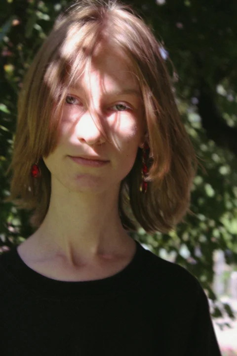 a woman standing in front of a tree