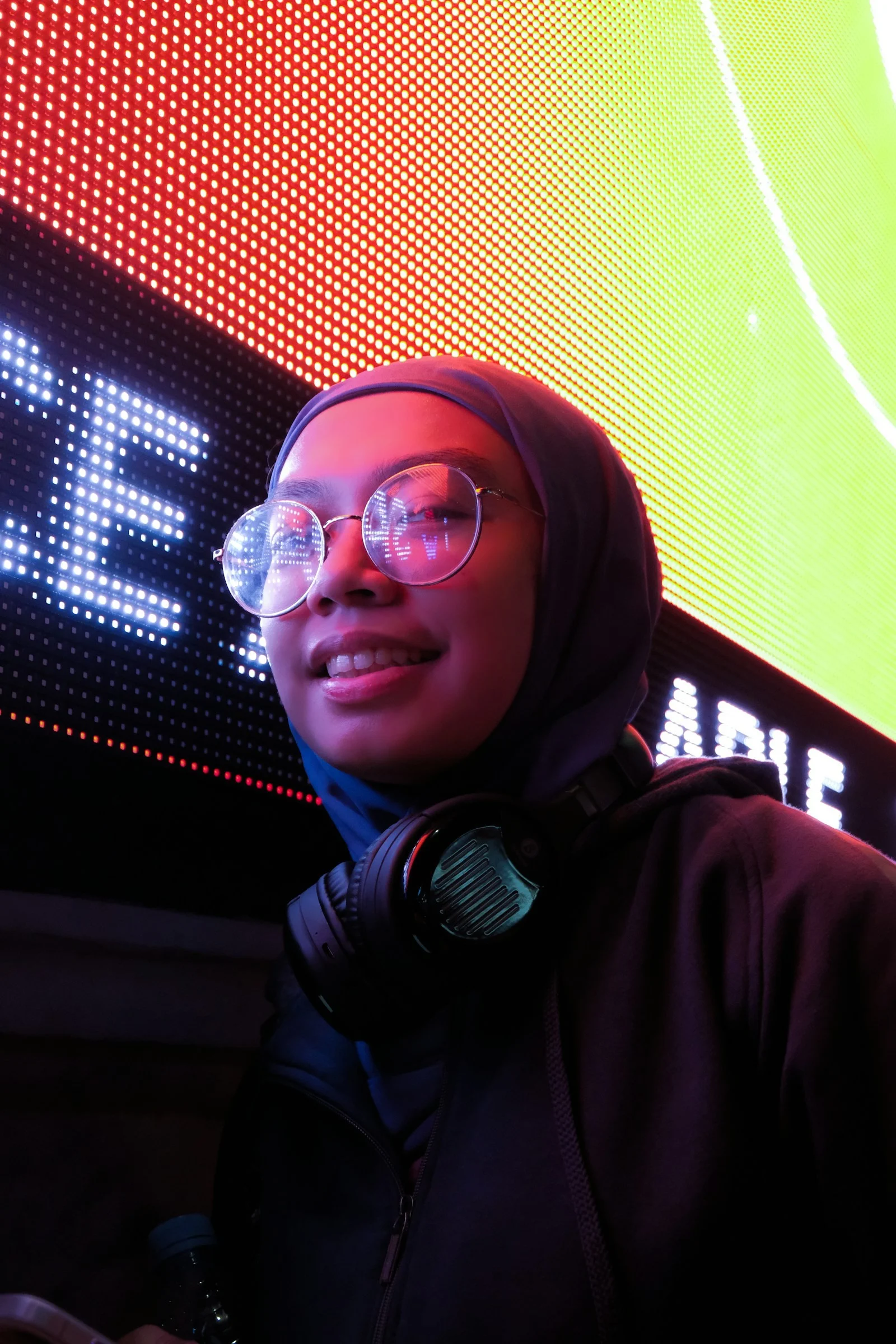 a person wearing a hoodie and sunglasses with a microphone in front of them