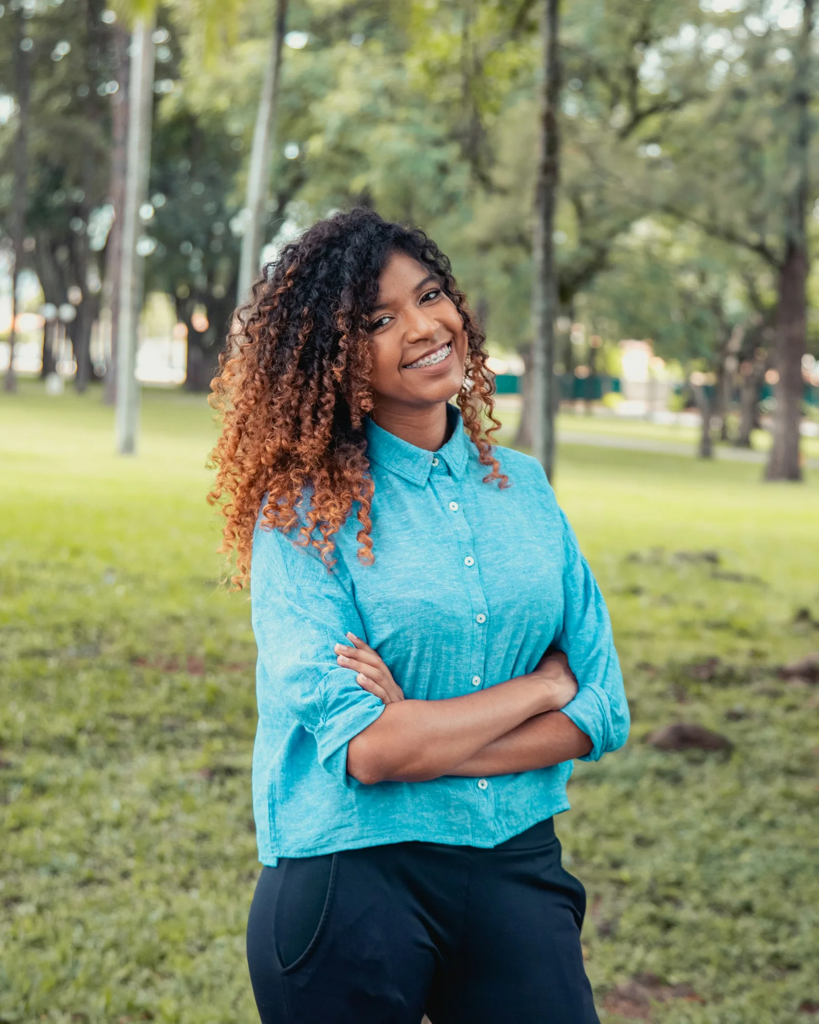 woman in blue long sleeve shirt standing on green grass field during daytime