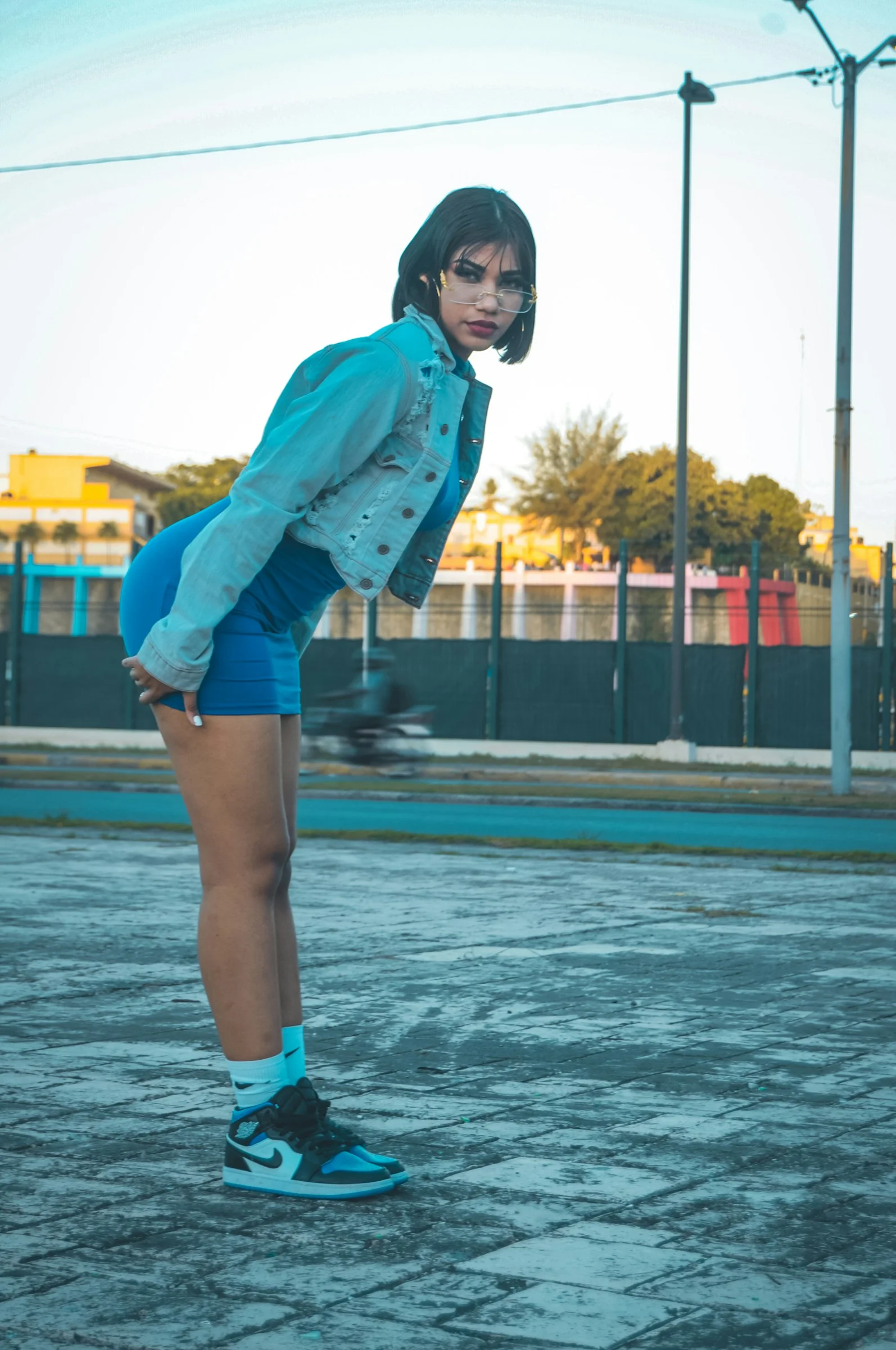 a woman standing on a skateboard in a parking lot