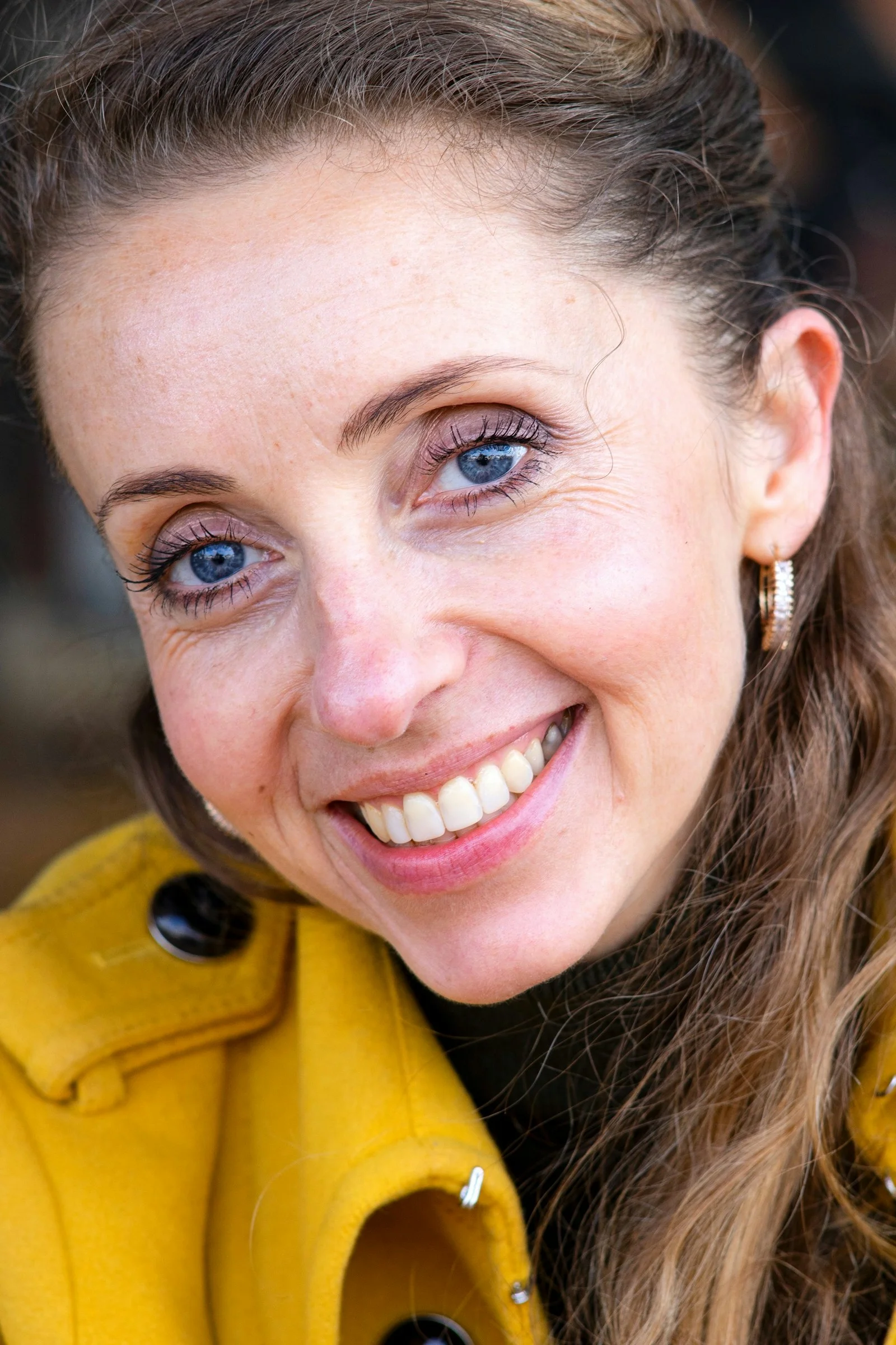 smiling woman in yellow jacket