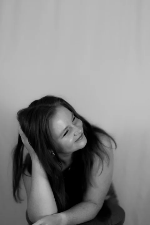 A black and white portrait of a smiling woman