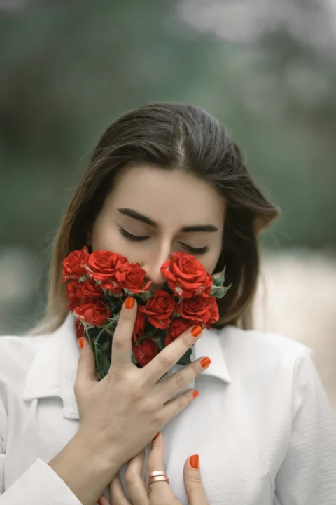 手持一束紅玫瑰的女性