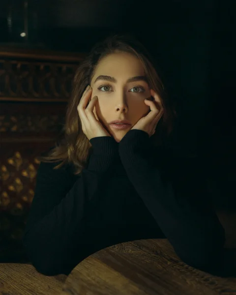 a woman sitting at a table with her hands on her face