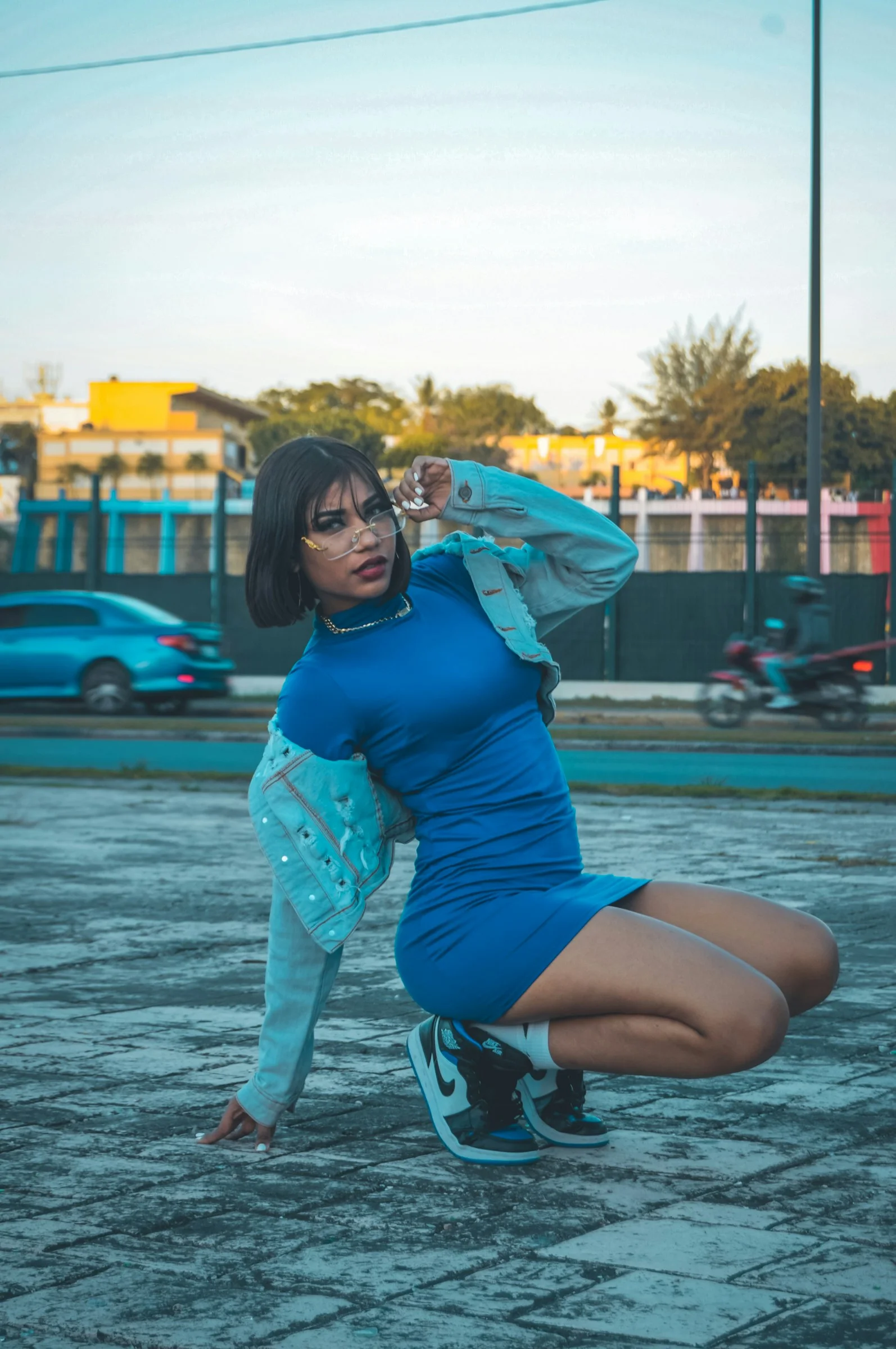 a woman in a blue dress kneeling on the ground