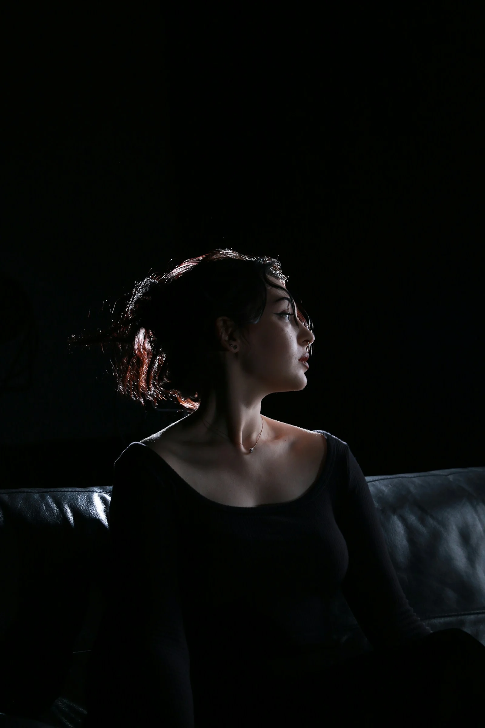 一名女子在黑暗中坐在沙發上
