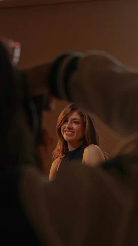 Smiling woman with long hair being photographed