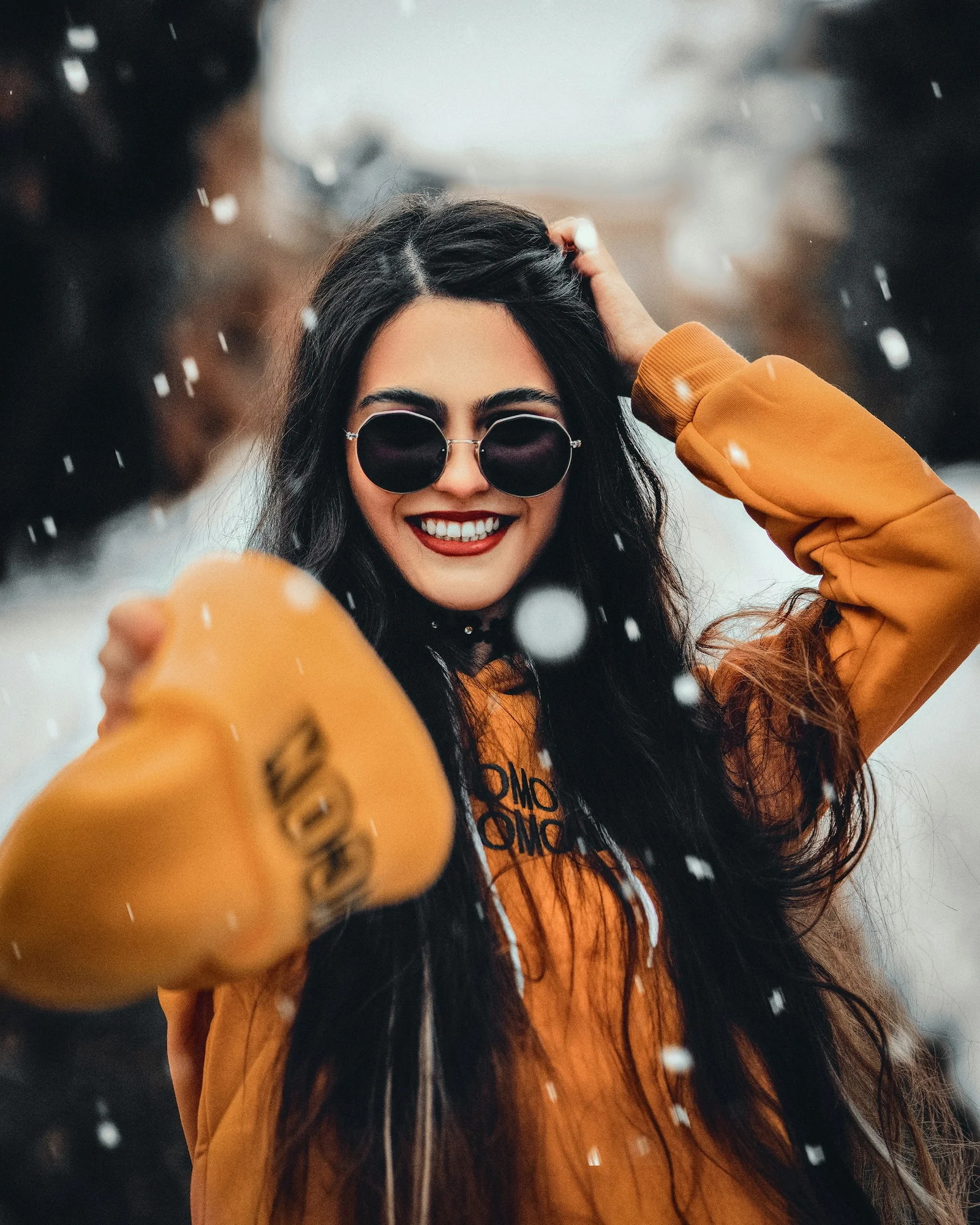 a woman wearing sunglasses and a hat in the snow
