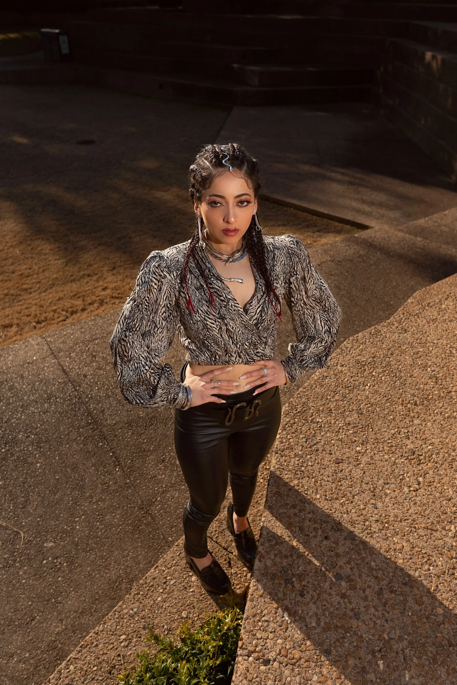 a woman standing on a sidewalk with her hands on her hips