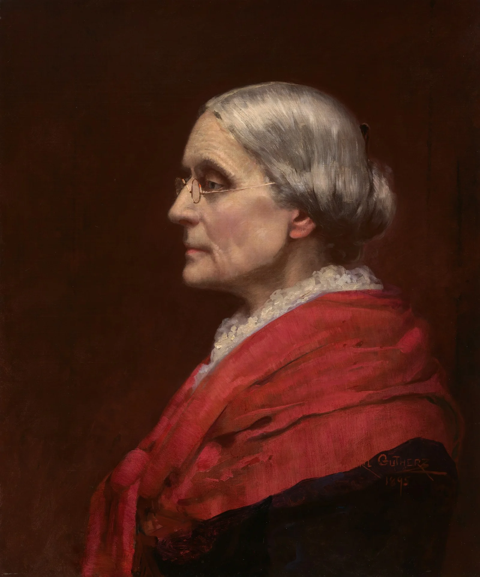 Older woman in profile wearing glasses and a red shawl