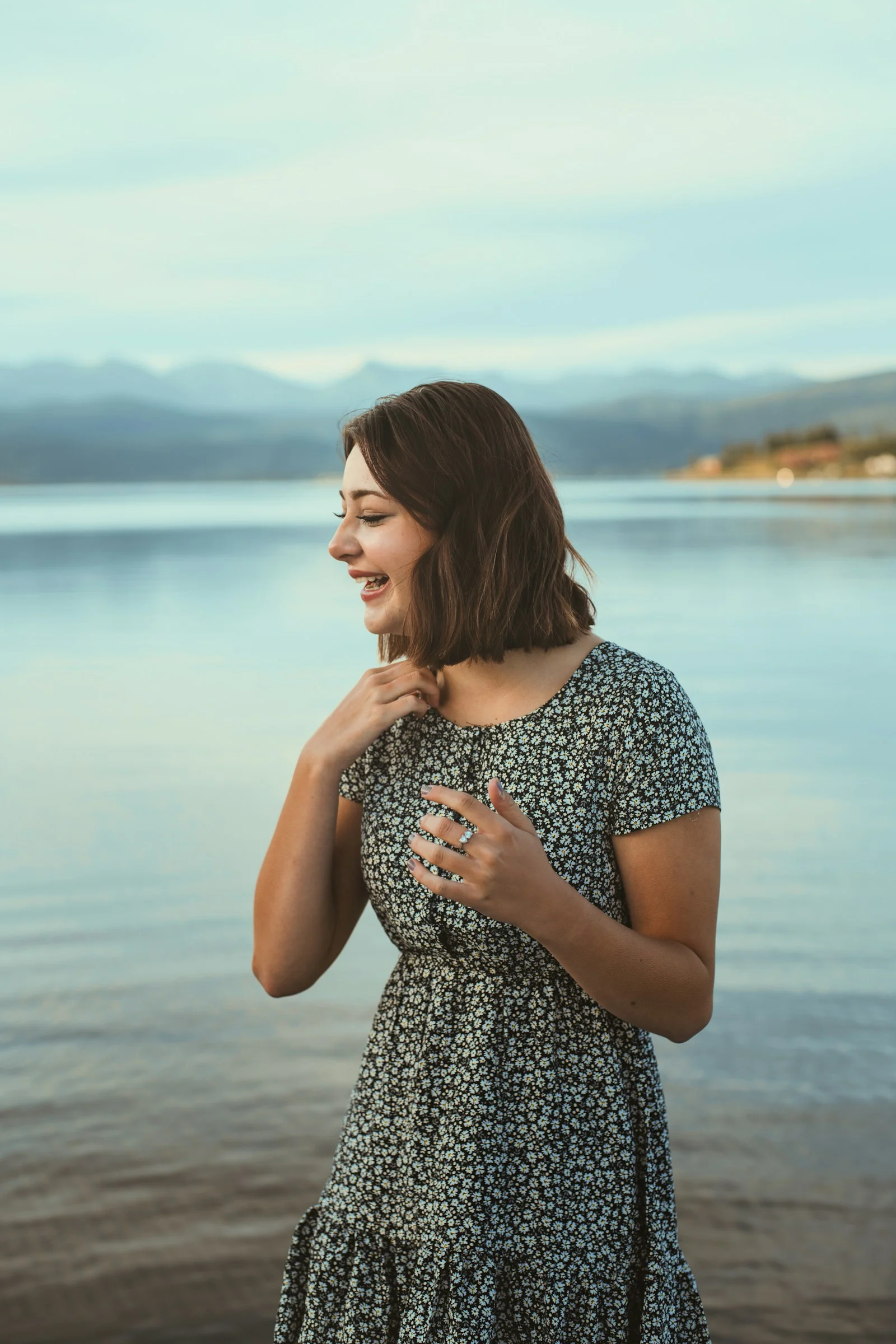 a woman standing on a beach next to a body of water