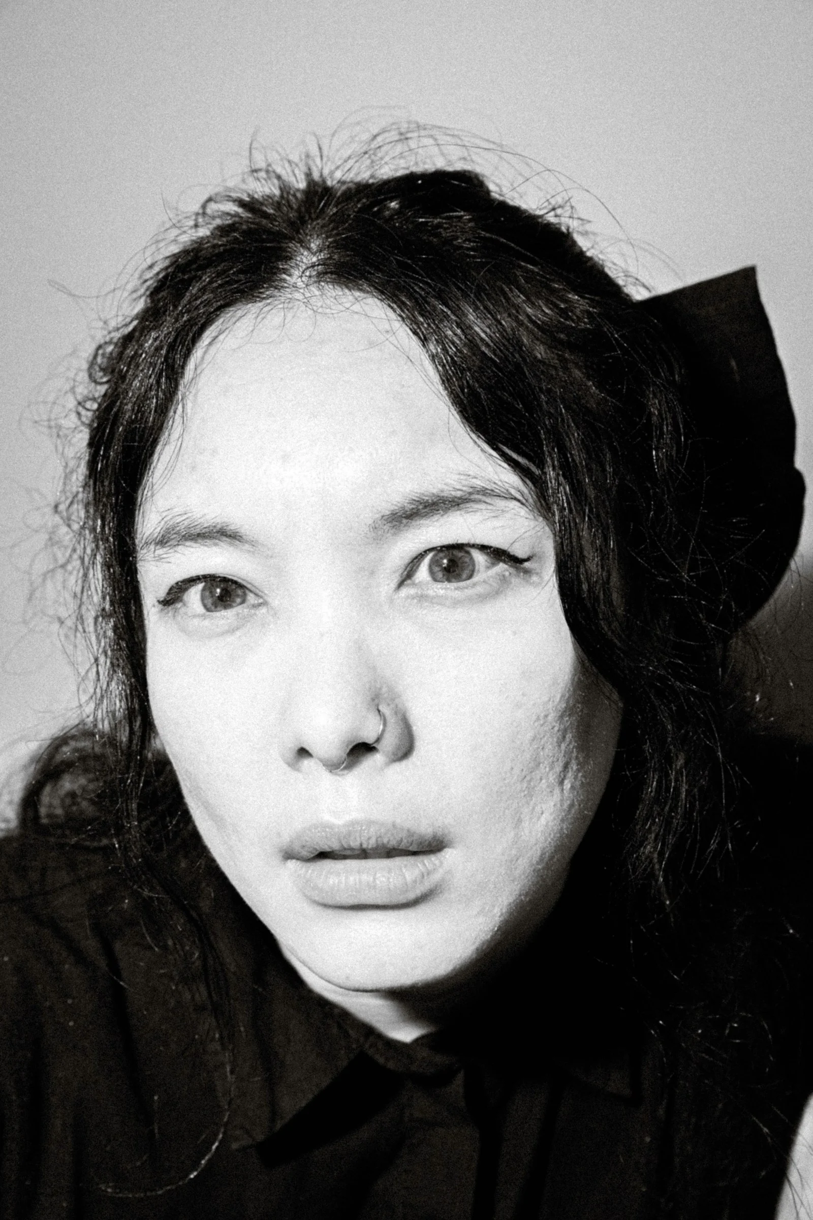 a black and white photo of a woman wearing a black shirt