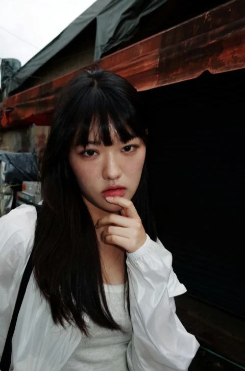 一个留着黑色长发、穿着白衬衫的女人