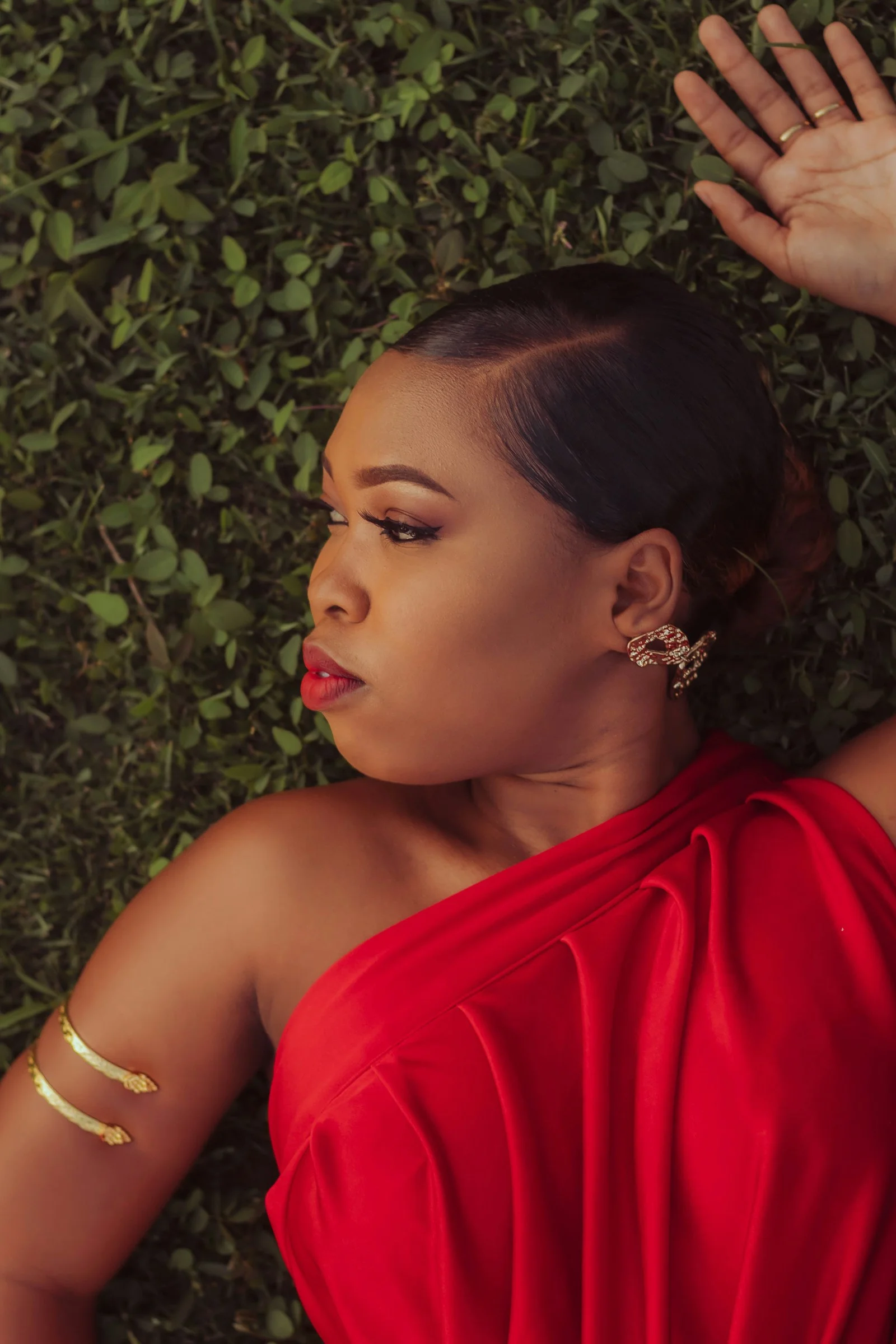 a woman in a red dress laying on the ground