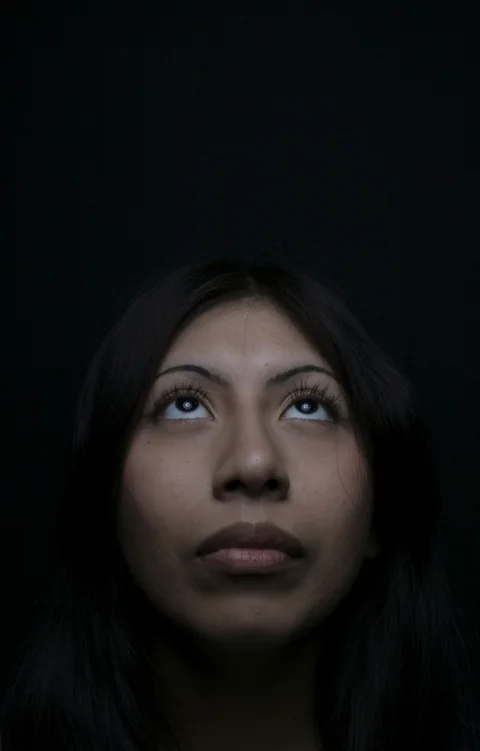 Woman looks up with a dark background