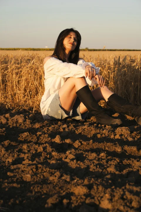女子坐在田野中，享受著陽光